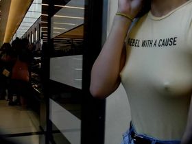 Парень снимает на камеру молодую девушку в узкой футболке со стоящими сосками